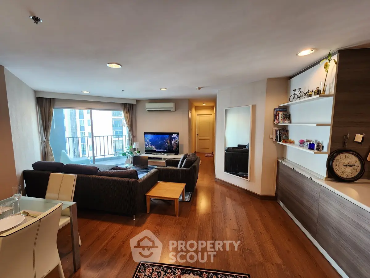 Spacious living room with modern decor and large windows offering city views.