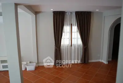 Spacious living room with terracotta tiles and elegant curtains