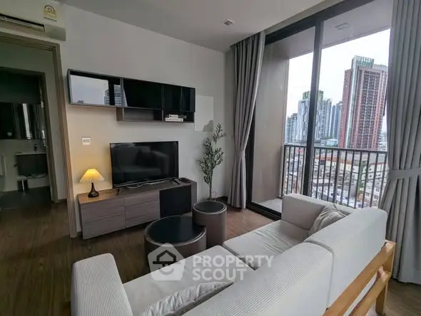 Modern living room with city view, featuring sleek furniture and large windows for natural light.