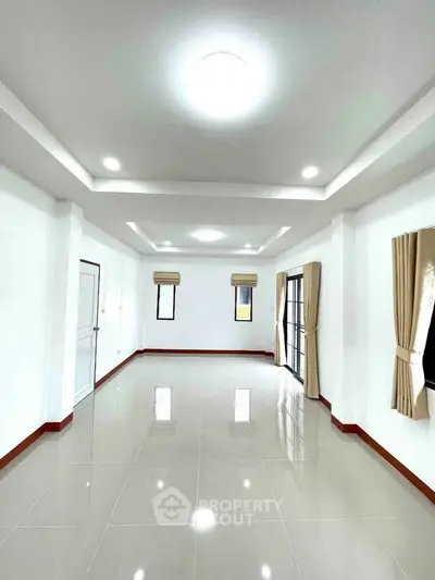 Spacious and bright living room with modern recessed lighting and large windows.