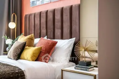 Luxurious bedroom with plush headboard and stylish decor, perfect for relaxation and comfort.