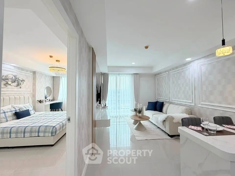 Modern open-plan living room and bedroom with stylish decor and natural light.