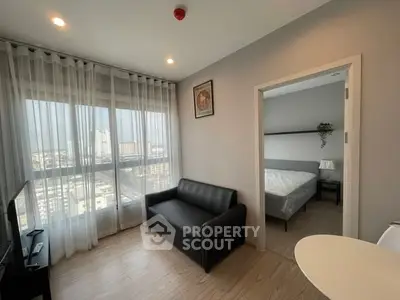 Modern apartment with cozy living room and bedroom, featuring large windows and city view.