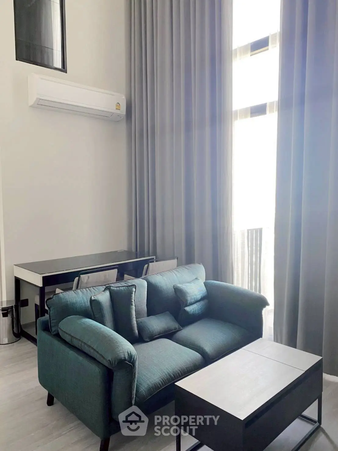 Modern living room with high ceilings, elegant curtains, and stylish furniture in a bright apartment.
