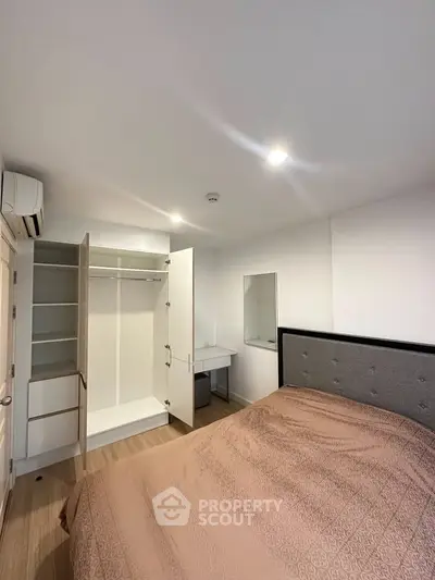 Modern bedroom with open wardrobe and stylish bed in a cozy apartment.