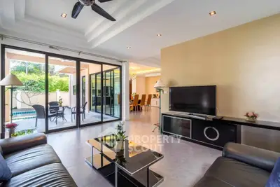Spacious living room with modern decor and pool view, perfect for relaxation and entertainment.