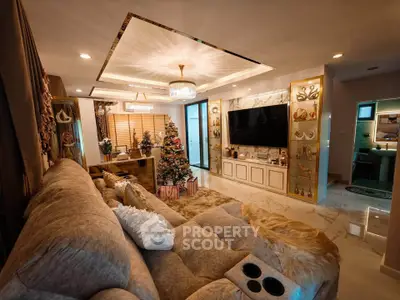 Luxurious living room with elegant decor and Christmas tree, featuring plush sofa and large TV.