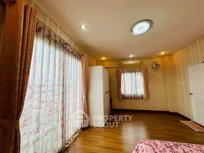 Spacious bedroom with elegant curtains and wooden flooring