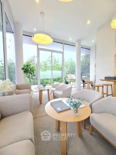 Spacious modern living room with elegant furniture and large windows offering garden views.