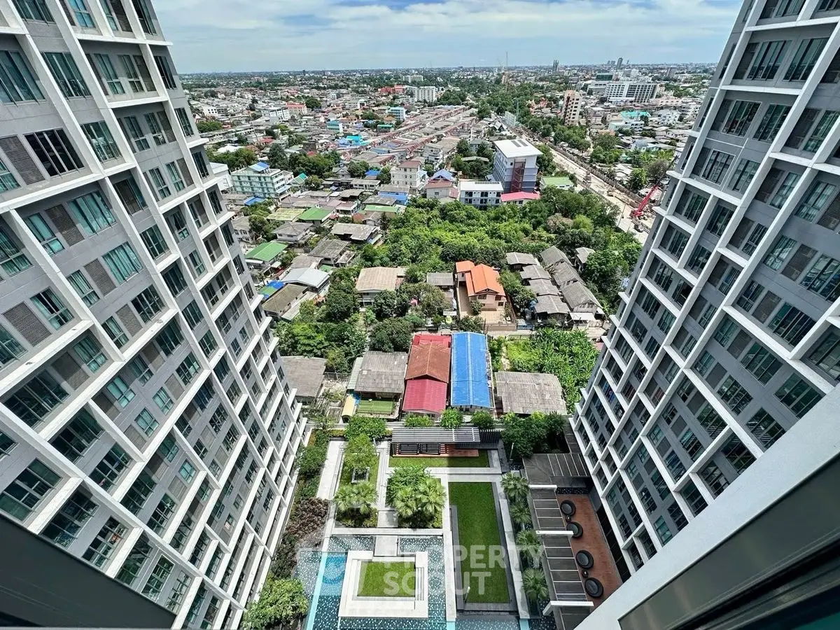Stunning high-rise view from modern apartment overlooking cityscape and lush greenery.