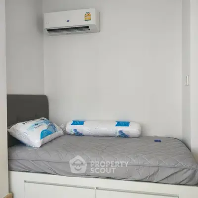 Cozy bedroom with air conditioning and modern bedding in a minimalist style.