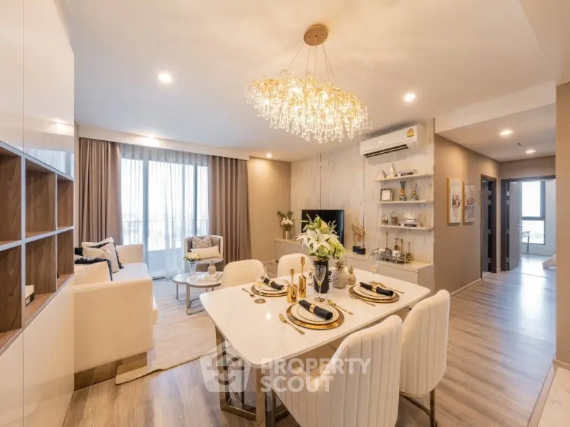 Luxurious open-plan living and dining area with elegant chandelier and modern decor.