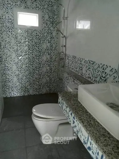 Charming bathroom with intricate tile design and modern fixtures.