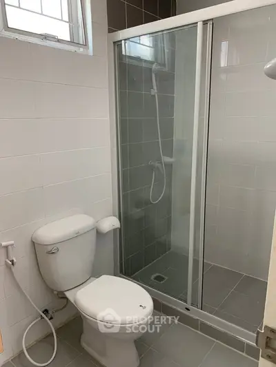 Modern bathroom with glass shower and white tiles, ideal for contemporary living.