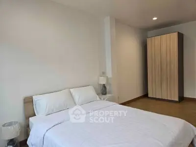 Spacious bedroom with modern decor and ample natural light, featuring a comfortable bed and stylish wardrobe.