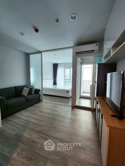 Modern apartment interior with living room and bedroom, featuring sleek design and natural light.