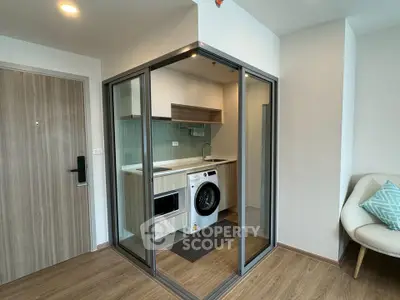 Modern compact kitchen with washing machine in stylish apartment