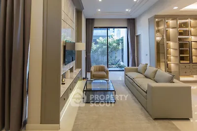 Luxurious living room with modern decor and large windows overlooking a garden.