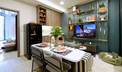 Modern living room with stylish decor and open kitchen layout, featuring a cozy dining area and elegant shelving.