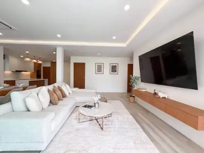 Spacious modern living room with large TV and open kitchen layout