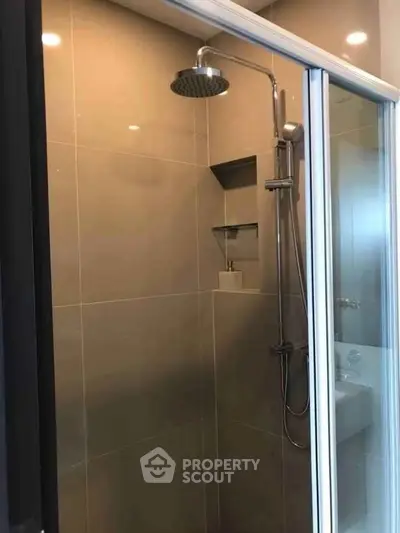Modern bathroom with sleek shower and glass door in contemporary apartment.