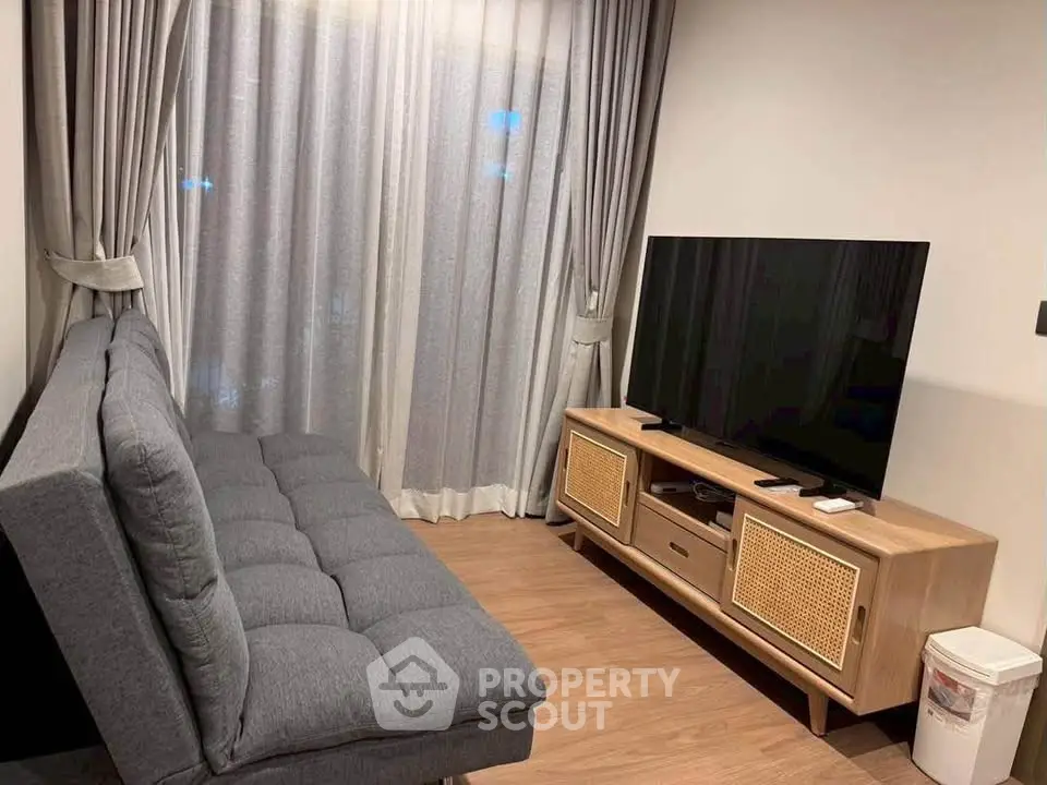 Modern living room with sleek grey sofa and stylish TV stand, perfect for cozy relaxation.