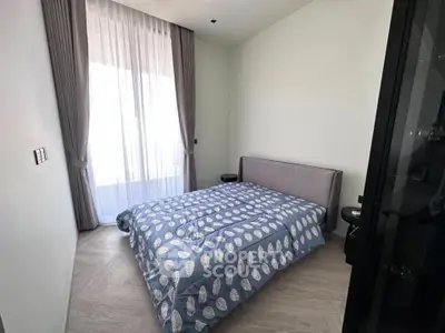 Modern bedroom with stylish decor and natural light, featuring a cozy bed and elegant curtains.