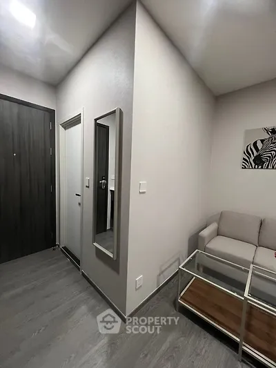 Modern living room with sleek design, featuring a cozy sofa, glass coffee table, and stylish wall art.
