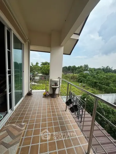 Spacious balcony with scenic green view, perfect for relaxation and outdoor enjoyment.