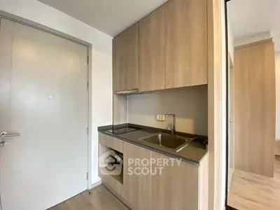 Compact modern kitchen with sleek wooden cabinets and stainless steel sink