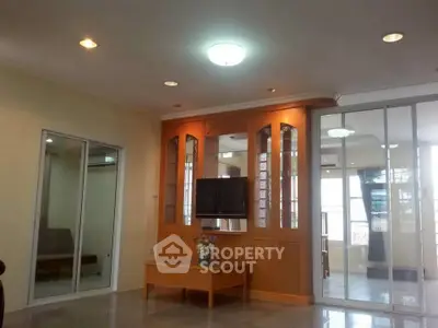 Spacious living room with built-in wooden entertainment center and sliding glass doors.