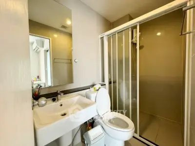 Modern bathroom with glass shower and sleek fixtures in a contemporary apartment.