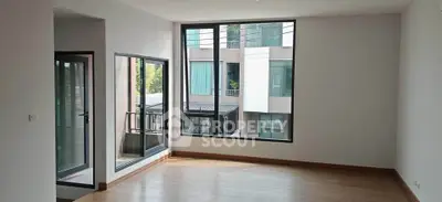 Spacious modern living room with large windows and balcony access in urban apartment