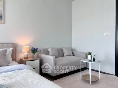 Cozy bedroom with stylish decor and comfortable seating area, perfect for relaxation.