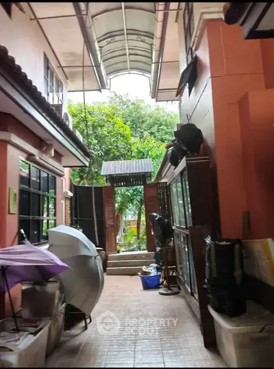Charming outdoor corridor with tiled flooring and lush greenery view
