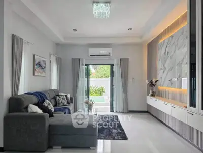 Spacious modern living room with elegant decor and pool view, perfect for relaxation and entertainment.