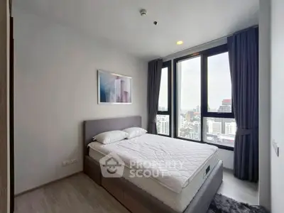 Modern bedroom with city view and large windows in high-rise apartment