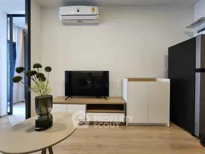 Modern living room with sleek TV stand, air conditioner, and stylish decor in a contemporary apartment.