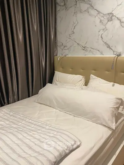 Luxurious bedroom with marble accent wall and plush bedding