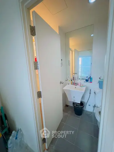 Modern bathroom with sleek fixtures and large mirror in a contemporary apartment.