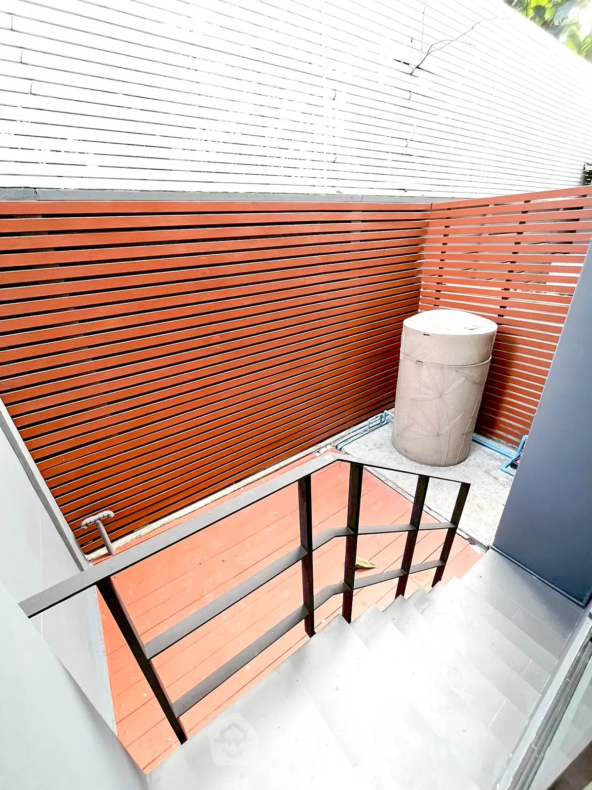 Modern outdoor staircase with sleek railing and privacy fence in contemporary home design.
