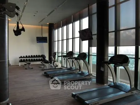 Luxurious high-rise gym with panoramic city views and modern fitness equipment.
