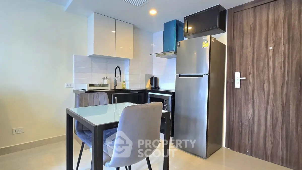 Modern kitchen with sleek appliances and dining area in stylish apartment