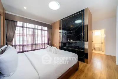 Luxurious bedroom with elegant decor and ensuite bathroom in modern apartment