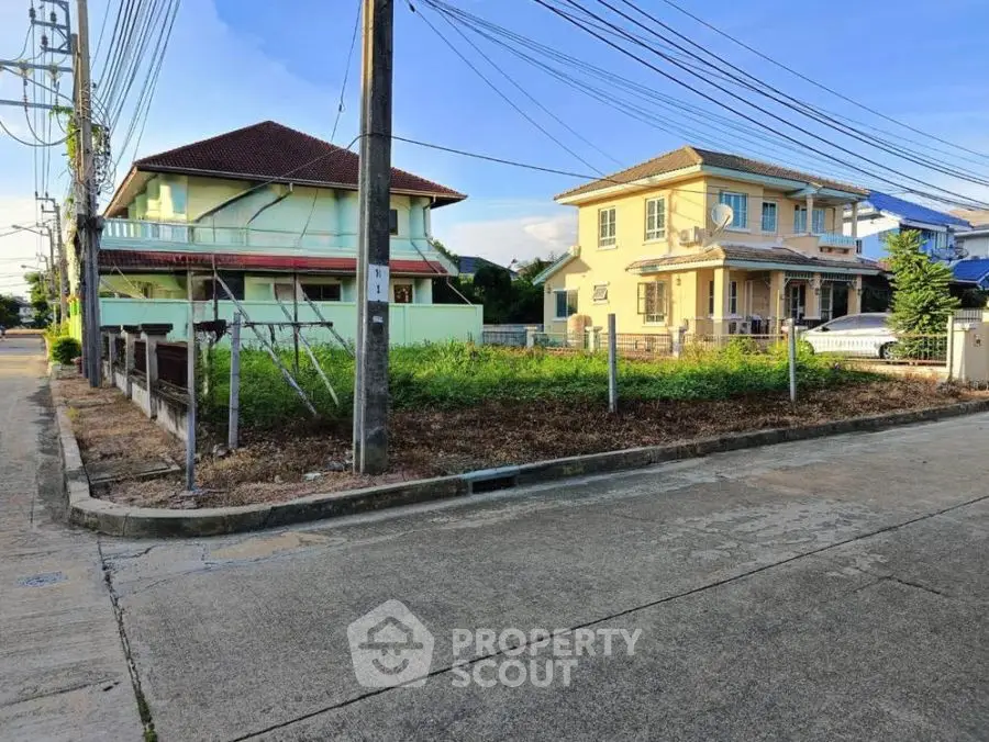 Corner residential plot with potential for development, surrounded by houses in a suburban neighborhood.