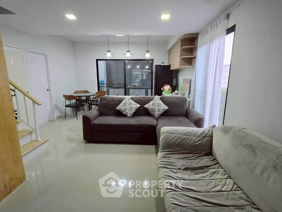 Modern living room with cozy sofas and dining area in open layout