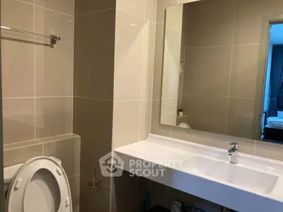 Modern bathroom with sleek design featuring large mirror and white fixtures