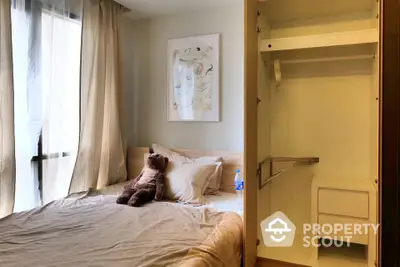 Cozy bedroom with plush teddy bear and open closet, perfect for relaxation.