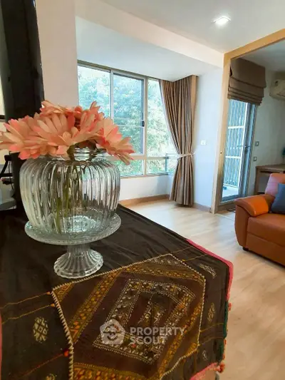 Charming living room with large window and elegant decor, offering a cozy and inviting atmosphere.