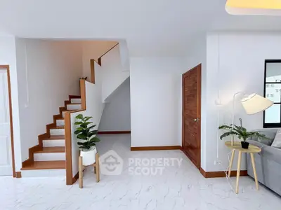 Modern interior with stylish staircase and cozy living area, featuring elegant decor and bright ambiance.